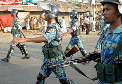 Riot police patrols a street after opposition supporters set fire to a train to protest the killing of lawmaker Ahsanullah Master in Tongi, outside Dhaka, Bangladesh, Friday, May 7, 2004. Gunmen opened fire at an opposition rally outside the capital of Bangladesh on Friday, killing four people including Master, his party and police said. (AP Photo/ Zia Islam)