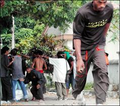 A man, carrying a home-made bomb, runs during clashes between two different groups in Ambon. Indonesia's security chiefs flew to riot-hit Ambon for talks with local leaders following four days of Muslim-Christian fighting which killed at least 37 people.(AFP)
