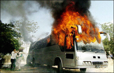 Two Pakistani men throw water as they attempt to douse the flames of a bus set on fire in Karachi. Riots have brought Karachi to a virtual standstill, with shopkeepers and public transport too scared of riots to operate.(AFP/Jewel Samad)