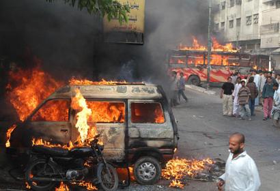 Angry crowds burn vehicles to protest the killing of Munawar Soharwardi,  a local leader of Benazir Bhutto's party, Thursday, June 17, 2004 in Karachi, Pakistan. The opposition politician and former bodyguard of former Prime Minister Benazir Bhutto was slain in a drive-by shooting in southern Pakistan on Thursday, triggering a riot by his supporters. (AP Photo/Shail Adil)